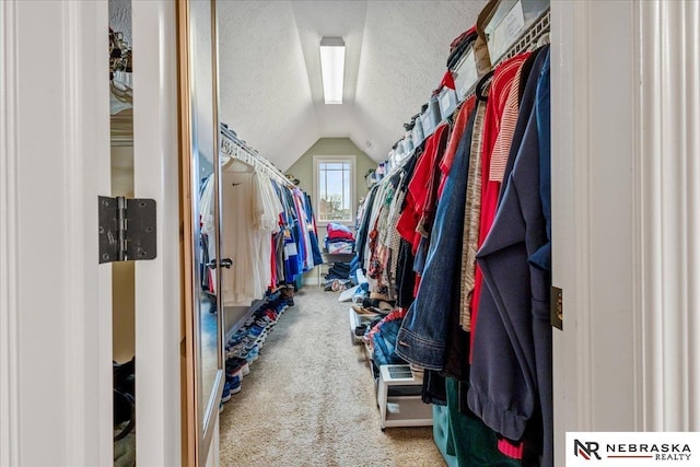 walk in closet with lofted ceiling and carpet