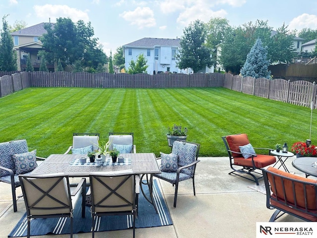 view of yard featuring a fenced backyard, outdoor dining space, and a patio area