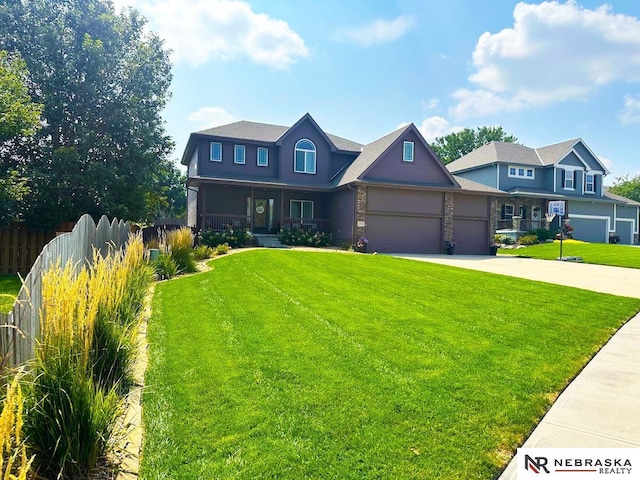 view of front of property with a front lawn, fence, covered porch, driveway, and an attached garage