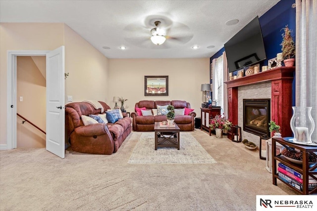 living area with recessed lighting, a fireplace with flush hearth, ceiling fan, and carpet