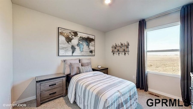 bedroom featuring visible vents, baseboards, and light carpet