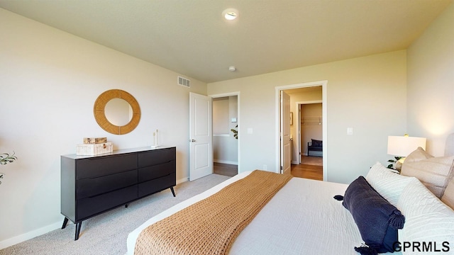 bedroom featuring visible vents, baseboards, and light colored carpet