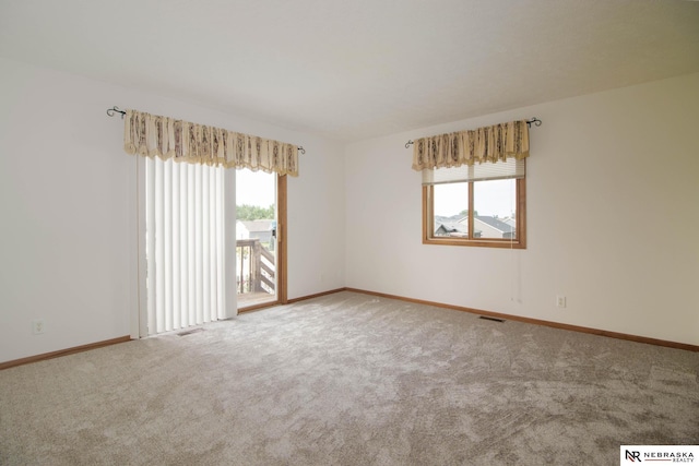 spare room with baseboards, carpet floors, and visible vents