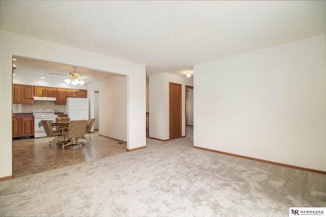 unfurnished living room with light colored carpet, baseboards, and ceiling fan