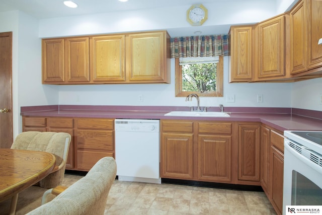 kitchen featuring white appliances, recessed lighting, brown cabinets, and a sink