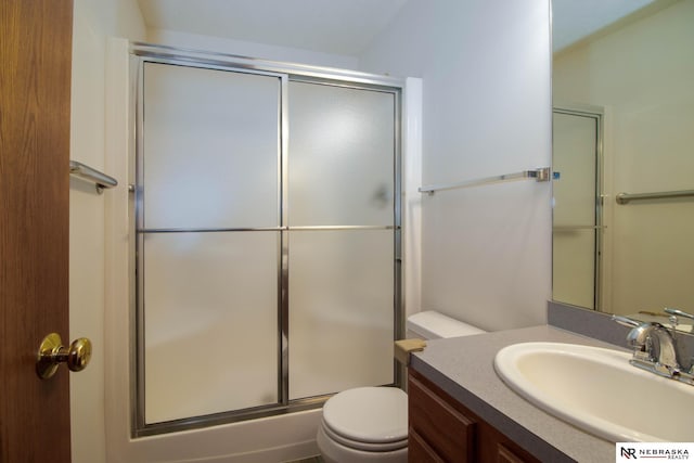 bathroom with a shower with door, toilet, and vanity