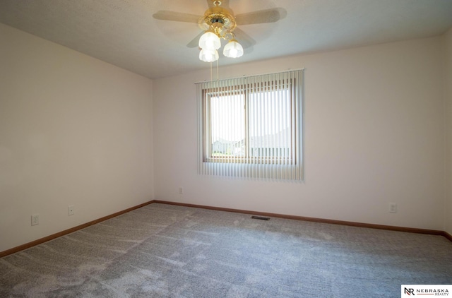 spare room featuring carpet flooring, baseboards, visible vents, and ceiling fan