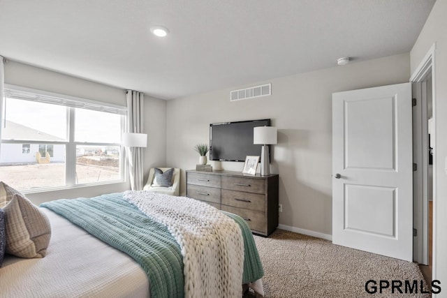 carpeted bedroom featuring visible vents and baseboards