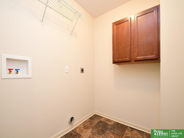 laundry room with baseboards, hookup for an electric dryer, cabinet space, washer hookup, and stone finish floor