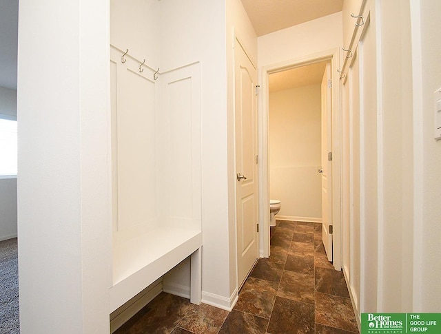 mudroom featuring stone finish floor and baseboards