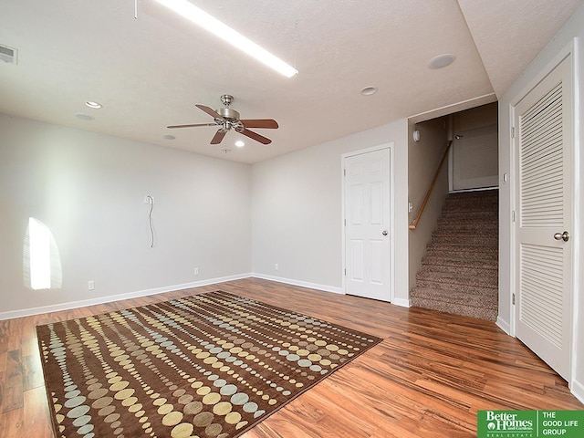 spare room featuring visible vents, baseboards, wood finished floors, and a ceiling fan