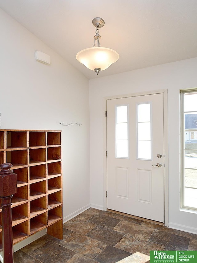 entryway featuring stone finish flooring, baseboards, and a healthy amount of sunlight