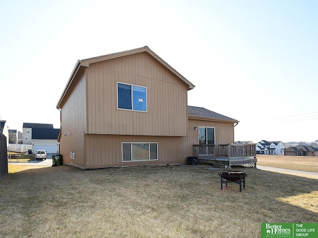 rear view of property with a wooden deck and a lawn