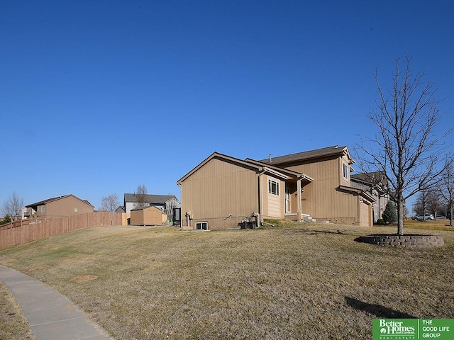 back of property with a yard, entry steps, and fence