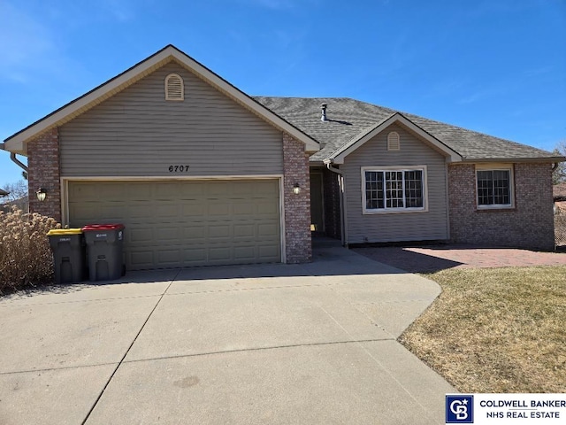 single story home with brick siding, concrete driveway, an attached garage, and a shingled roof