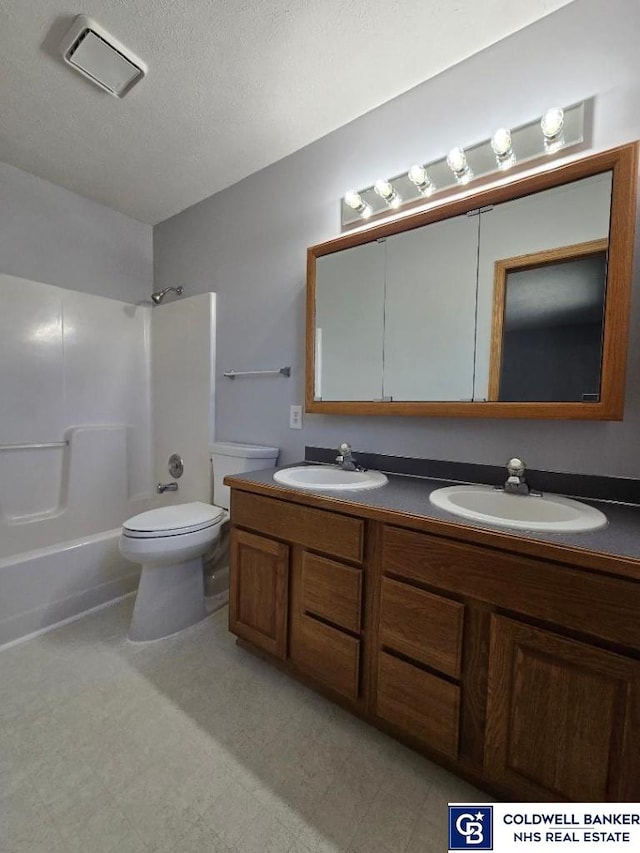 bathroom featuring double vanity, toilet, shower / washtub combination, and a sink