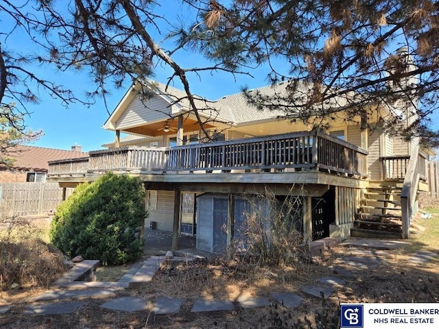 back of property with a ceiling fan, stairway, fence, and a wooden deck