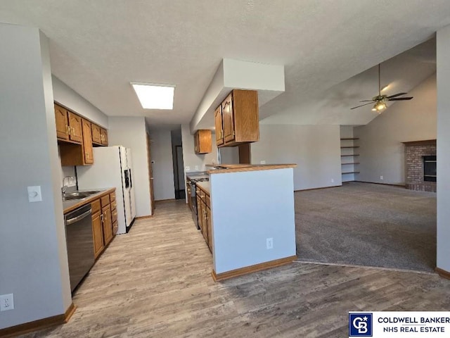 kitchen with dishwasher, brown cabinetry, light wood-style floors, and ceiling fan