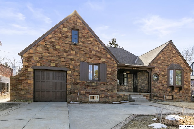 view of front of property with brick siding, concrete driveway, and a shingled roof