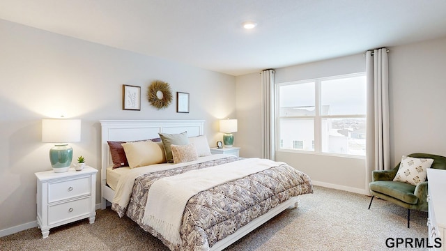 bedroom with baseboards and light carpet