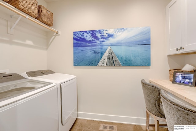 washroom featuring washing machine and dryer, cabinet space, visible vents, and baseboards