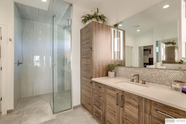 bathroom featuring tasteful backsplash, tile patterned flooring, walk in shower, recessed lighting, and vanity