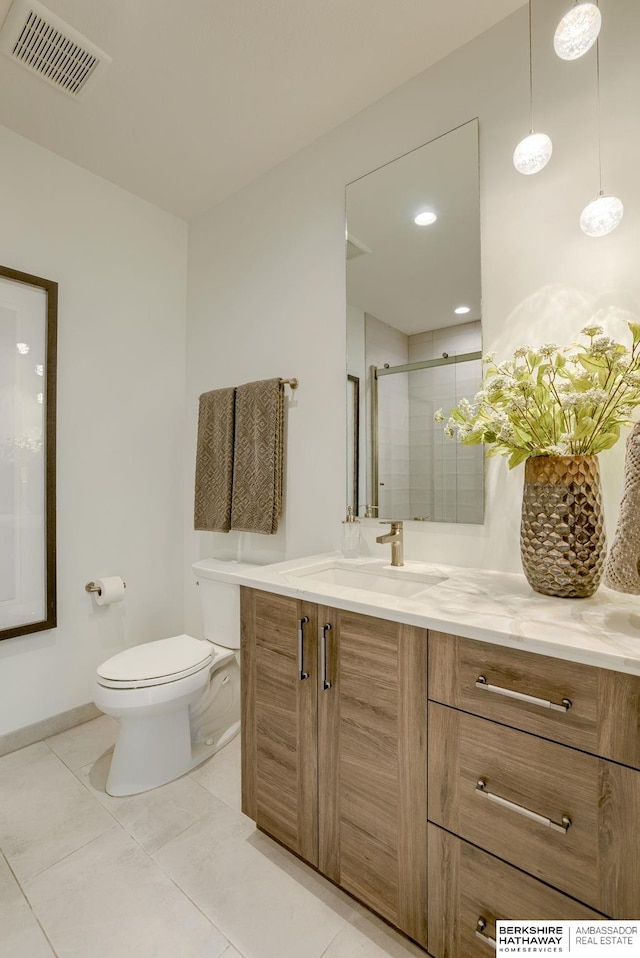 bathroom with vanity, a shower stall, toilet, and visible vents