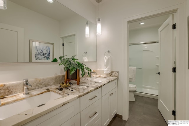 bathroom with a sink, toilet, double vanity, and a shower stall