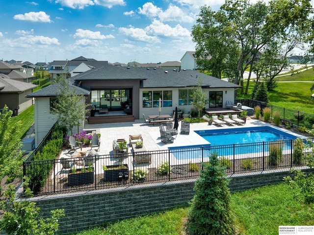 rear view of house featuring a patio, fence, a fenced in pool, outdoor dining area, and an outdoor hangout area