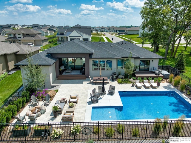 back of house featuring a deck, a patio, an outdoor living space with a fire pit, and a fenced backyard