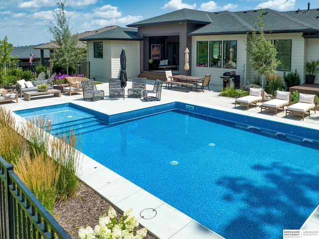 view of swimming pool featuring outdoor lounge area, a fenced in pool, a patio area, and fence