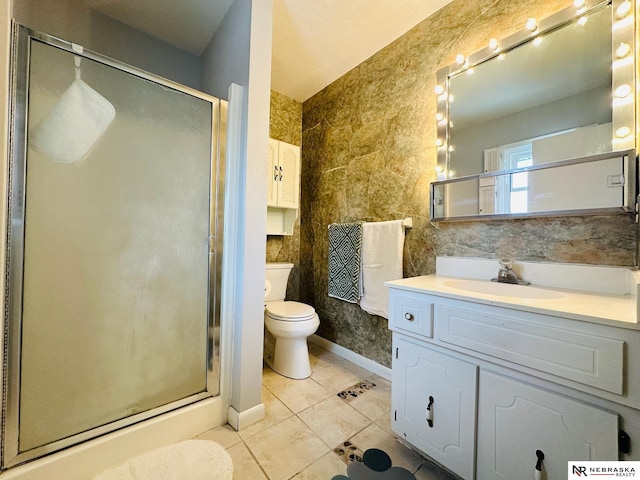 bathroom featuring vanity, a stall shower, tile walls, toilet, and tile patterned floors