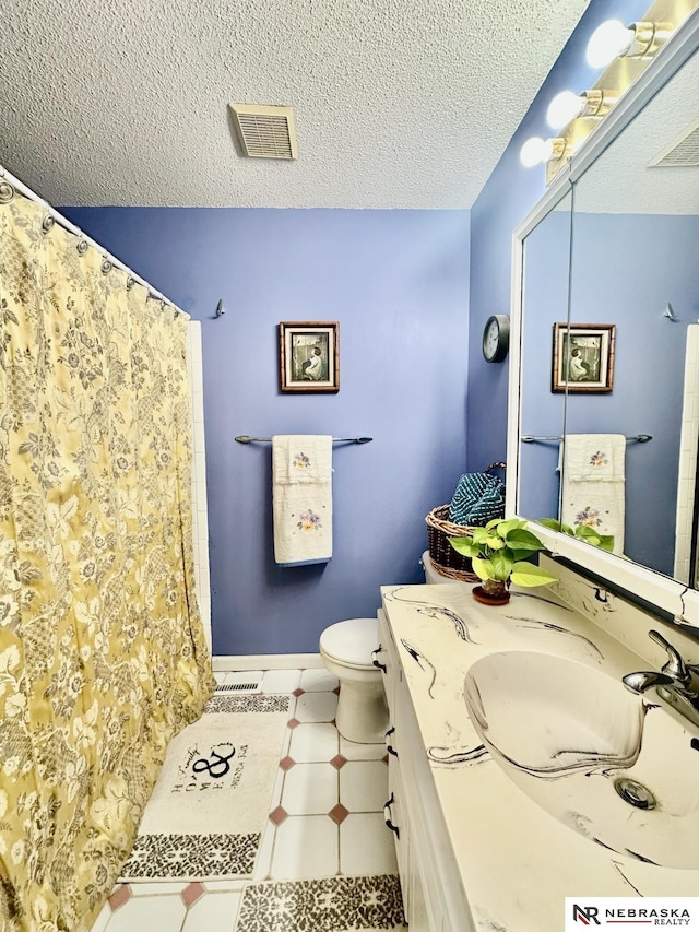 bathroom with visible vents, toilet, a textured ceiling, and vanity