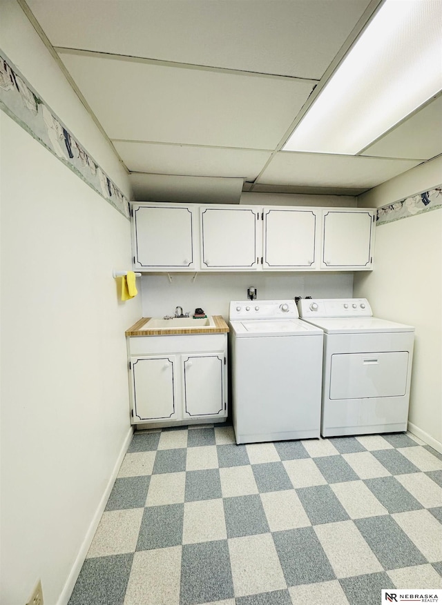 laundry room featuring a sink, baseboards, cabinet space, and washer and clothes dryer