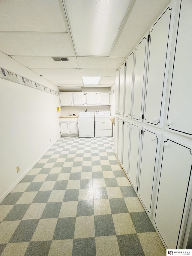 interior space with washing machine and clothes dryer, visible vents, cabinet space, and baseboards