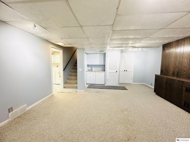 finished basement with stairway, visible vents, baseboards, carpet flooring, and independent washer and dryer