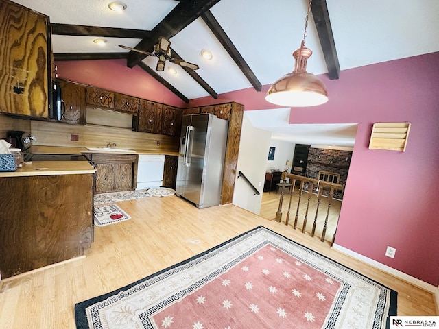 kitchen with high quality fridge, vaulted ceiling with beams, white dishwasher, black microwave, and range