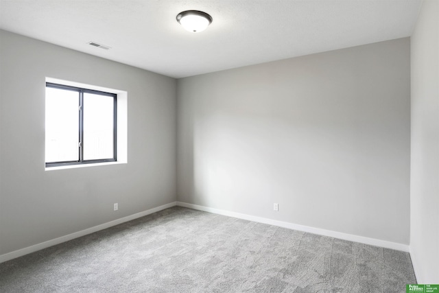 empty room featuring visible vents, baseboards, and carpet flooring