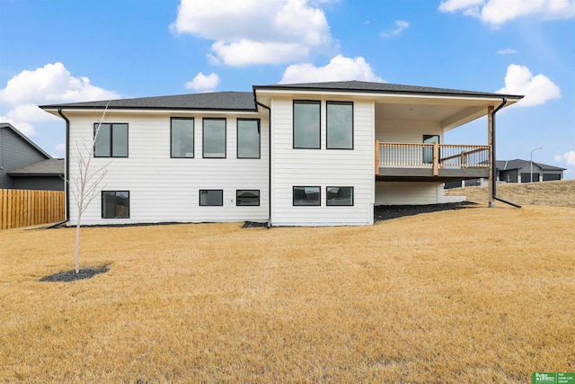 rear view of property with a yard and fence