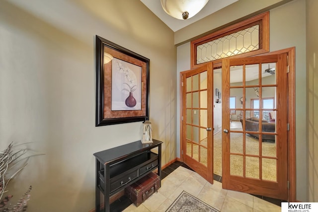 doorway featuring light tile patterned flooring and baseboards