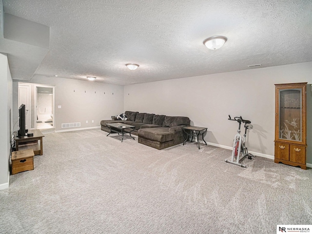 carpeted living room with visible vents, a textured ceiling, and baseboards