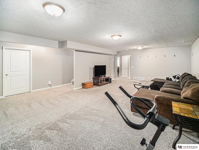 living area with visible vents, carpet flooring, a textured ceiling, and baseboards