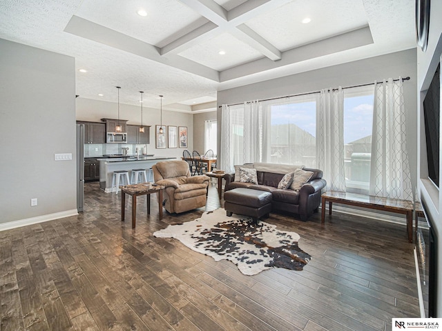 living area featuring baseboards, beamed ceiling, coffered ceiling, a textured ceiling, and dark wood-style flooring