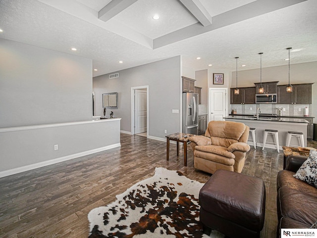 living area with visible vents, baseboards, beam ceiling, recessed lighting, and dark wood-type flooring