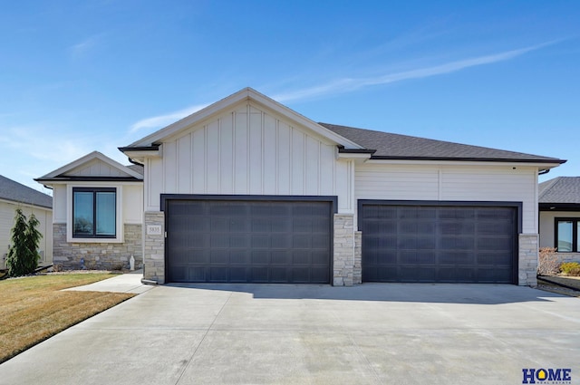 view of front of house featuring a shingled roof, concrete driveway, a front lawn, a garage, and board and batten siding