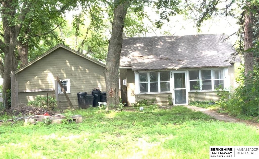 rear view of property with a yard and a sunroom