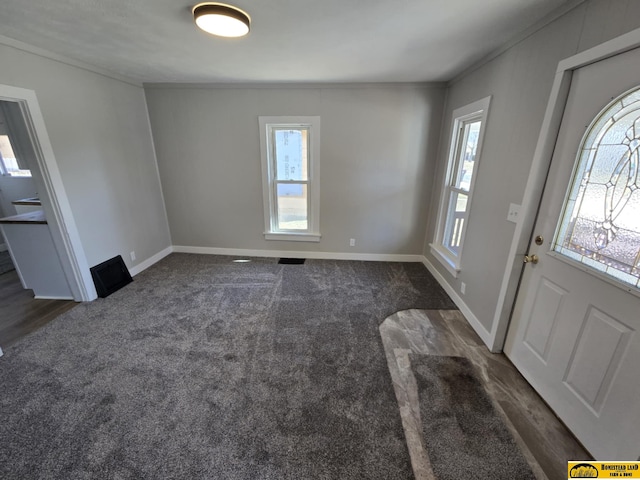 entrance foyer with carpet flooring, baseboards, and ornamental molding