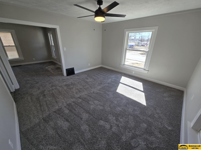 unfurnished bedroom with ceiling fan, a textured ceiling, baseboards, and dark colored carpet