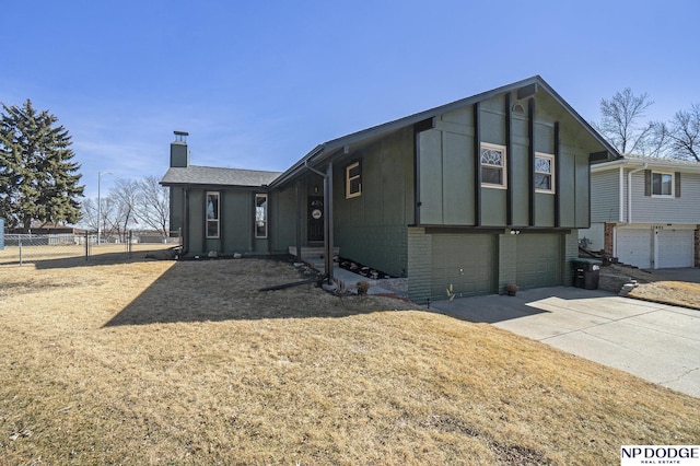 view of front of home with fence, driveway, a chimney, a garage, and brick siding