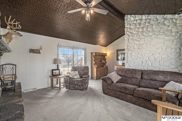 living area with visible vents, carpet floors, ceiling fan, and vaulted ceiling with beams